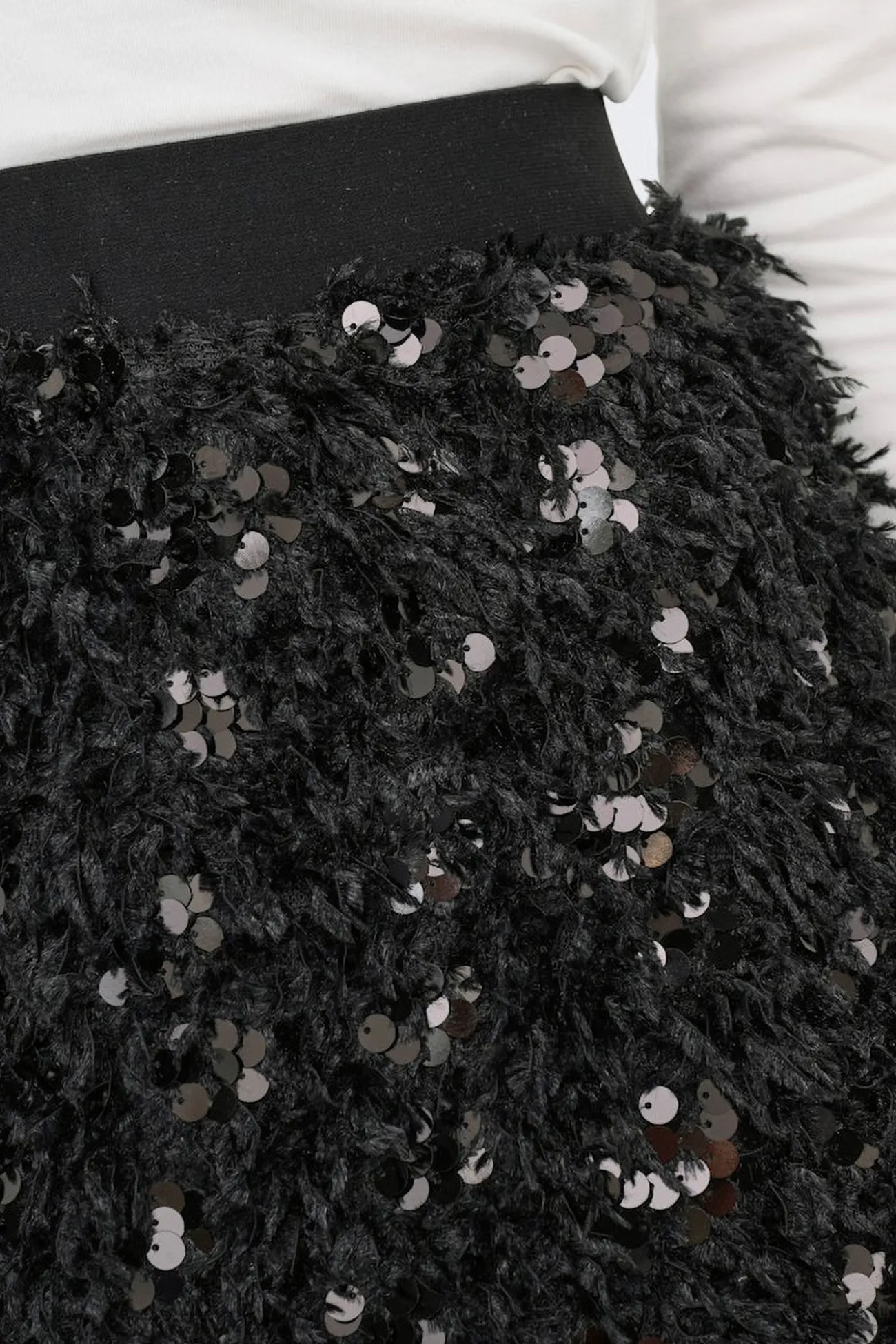 Falda corta de plumas y lentejuelas